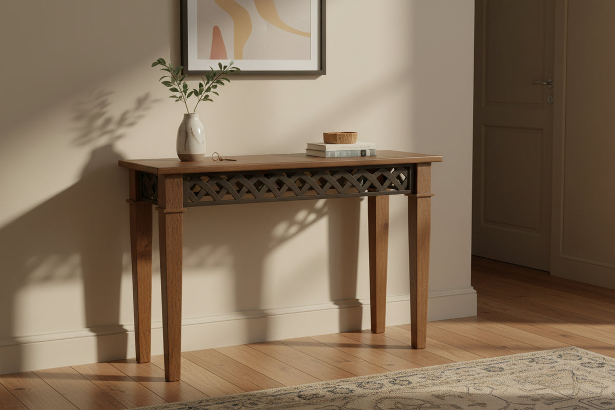 A wooden console table with a medium brown finish and a black metal geometric lattice pattern across the front, set against a plain off-white wall and beige carpet.